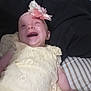 Lilyann is registered to the contest to win money with this photo: baby, bed, blanket, child, cute, dress, flower_headband, happy, headband, indoors, infant, infant_clothing, laughing, lying_down, person, portrait, skin, smiling, striped_sheets, yellow_dress