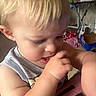 toddler, child, blonde_hair, thumb_sucking, close_up, indoor, casual_clothing, person, baby, cute, face, skin, arm, expression, thoughtful, home, clutter, background, soft_light, portrait