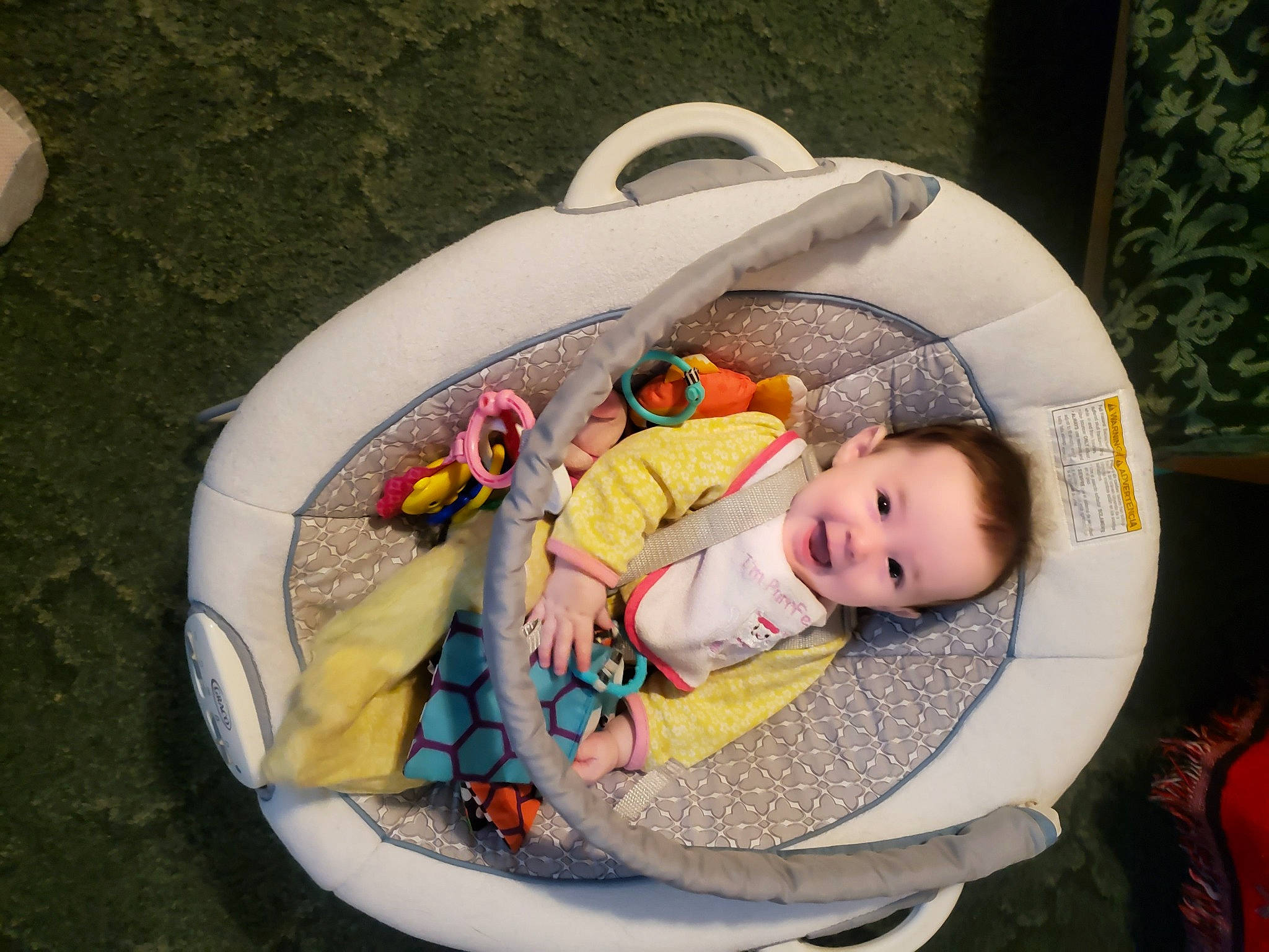 Arabella is registered to the contest to win money with this photo: baby, baby_carriage, baby_products, baby_safety, baby_toddler_clothing, baby_toys, bathing, child, circle, comfort, fashion_accessory, grass, infant_bed, joy, person, personal_protective_equipment, sitting, toddler