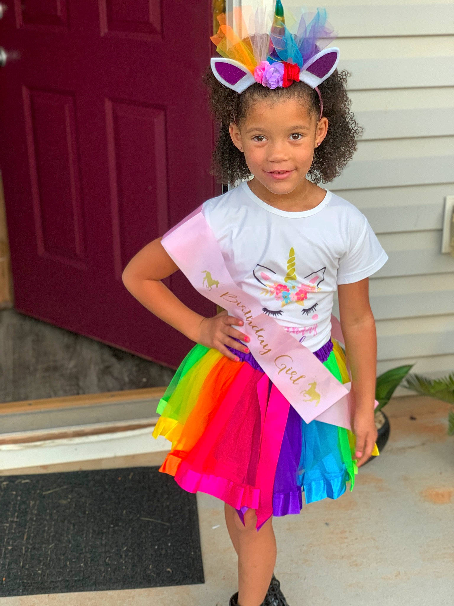 Qiana is registered to the contest to win money with this photo: baby_toddler_clothing, child, clothing, costume, costume_hat, door, event, facial_expression, fun, hairstyle, happy, headpiece, joy, magenta, party_hat, party_supply, person, pink, purple, sandal