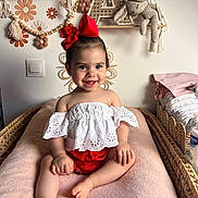Ava a rejoint le concours — aidez-le/la à gagner de superbes lots ! toddler, child, smile, red_bow, white_top, pink_blanket, nursery, plush_toy, crochet, decor, flower, basket, woven_furniture, cute, happy, baby, indoors, portrait, sitting, handmade