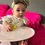 Ava is registered to the contest to win money with this photo: baby, child, high_chair, headband, bow, teething_toy, pink, cushion, soft_focus, indoor, cute, infant, clothing, hand, foot, person, portrait, happy, table, baby_girl