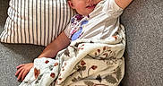 Scotlyn is registered to the contest to win money with this photo: blanket, casual_clothing, child, comfortable, couch, cozy, face, hair, happy, home, indoor, kid, patterned_blanket, pillow, portrait, relaxing, resting, smile, striped_pillow, young_child