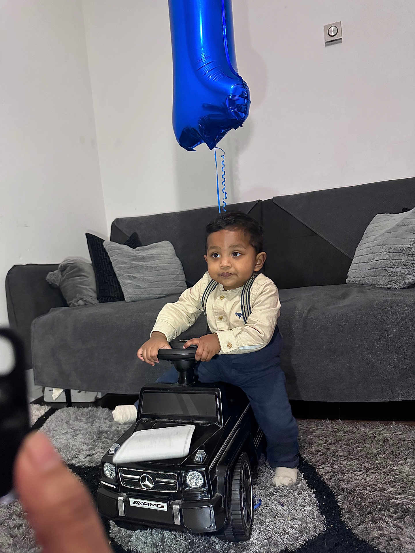 Yaqub joined the competition — help win amazing prizes! toddler, child, toy_car, mercedes, amg, balloon, number_one, living_room, couch, cushion, carpet, indoor, clothing, socks, person, floor, playing, furniture, cute, baby