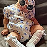 Juliana joined the competition — help win amazing prizes! baby, child, sunglasses, headband, white_clothing, blue_pattern, socks, bows, sitting, couch, indoor, cute, fashion, portrait, infant, relaxed, comfortable, person, accessory, funny