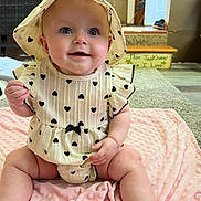 Everly joined the competition — help win amazing prizes! baby, infant, smiling, hat, dress, heart_pattern, blanket, pink, indoor, carpet, home, cute, child, sitting, happy, person, face, chubby_legs, soft_texture, cozy
