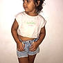 Aya a rejoint le concours — aidez-le/la à gagner de superbes lots ! child, curly_hair, denim_shorts, white_tshirt, standing, indoor, tiled_floor, wall, casual_clothing, portrait, barefoot, young, looking_away, hands, smile, shorts, cute, skin, floor_tile, posing