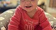 Zonasue joined the competition — help win amazing prizes! baby, infant, smiling, pink_onesie, socks, cute, happy, child, portrait, indoors, cushion, hand, feet, sitting, face, person, soft_background, cozy, playful, young