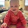 baby, infant, smiling, pink_onesie, socks, cute, happy, child, portrait, indoors, cushion, hand, feet, sitting, face, person, soft_background, cozy, playful, young
