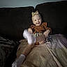 baby, blanket, bow, brown_outfit, child, couch, furniture, happy, headband, home, indoor, infant, kicking, motion_blur, plaid_skirt, portrait, sitting, smiling, socks, soft_lighting