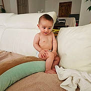 Seiji participe au concours pour gagner de l'argent avec cette photo : baby, child, indoor, couch, blanket, pillow, diaper, furniture, curious, infant, soft, cozy, home, living_room, cute, person, seated, expression, skin, small