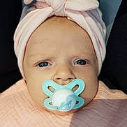 Léonie participe au concours pour gagner de l'argent avec cette photo : baby, pacifier, headwrap, pink, blue_eyes, close_up, infant, blanket, cute, face, child, newborn, soft_light, portrait, indoors, expression, wrapped, wearing, headwear, skin