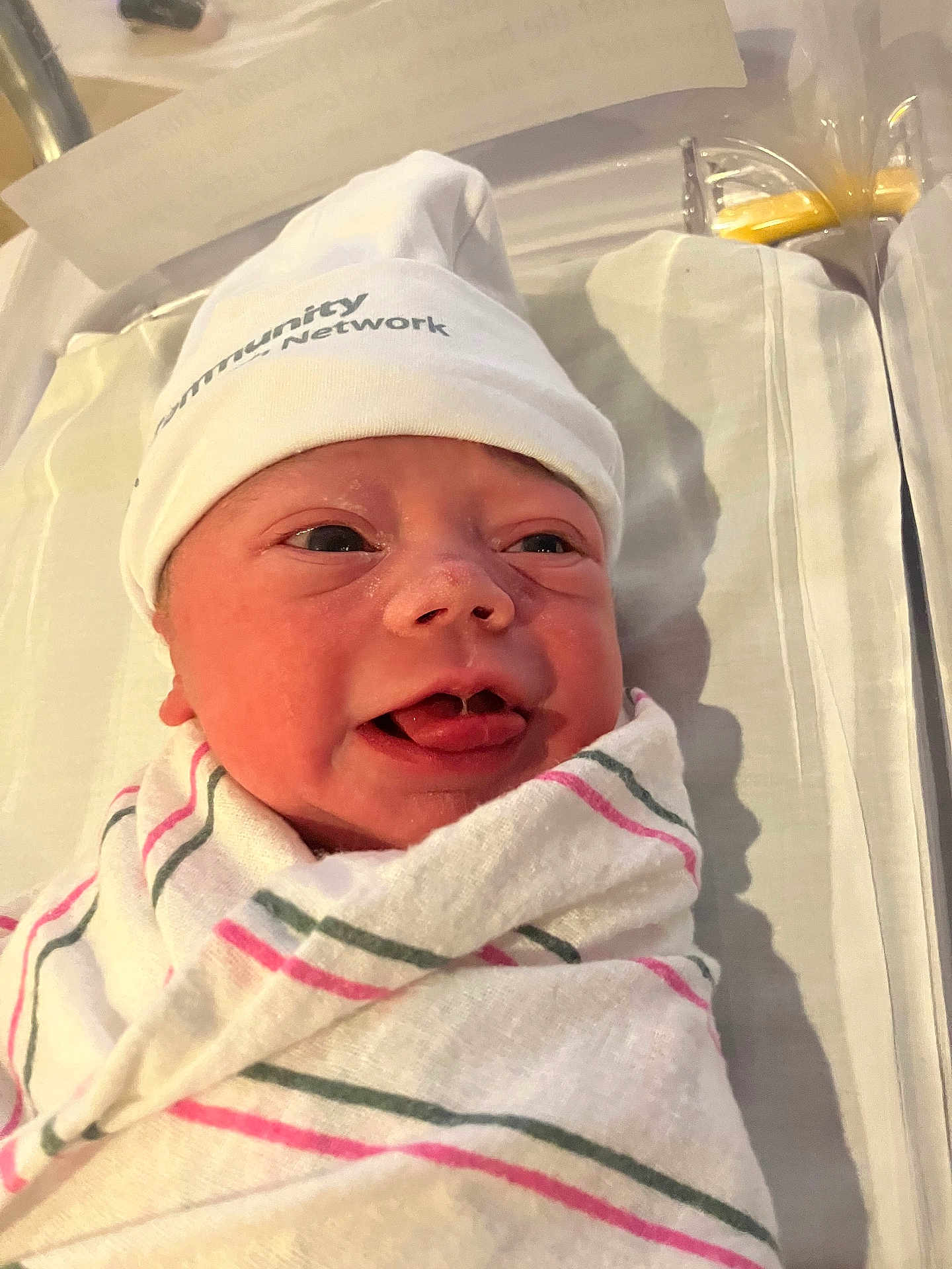 Rosaleigh joined the competition — help win amazing prizes! newborn, baby, infant, hospital, blanket, hat, bassinet, swaddled, face, expression, tongue, skin, person, cute, healthcare, bed, white, pink, green, lying