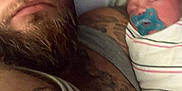 Rosaleigh is registered to the contest to win money with this photo: baby, beard, bed, blanket, closeup, expression, family, indoor, intimate, love, man, pacifier, person, pillow, portrait, resting, skin, sleeping, swaddled, tattoo