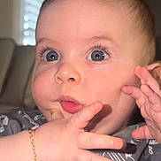 Anthuan is registered to the contest to win money with this photo: baby, infant, child, face, eyes, eyelashes, hand, fingers, bracelet, onesie, clothing, portrait, close_up, indoor, window, blinds, couch, pink_lips, cheeks, adorable