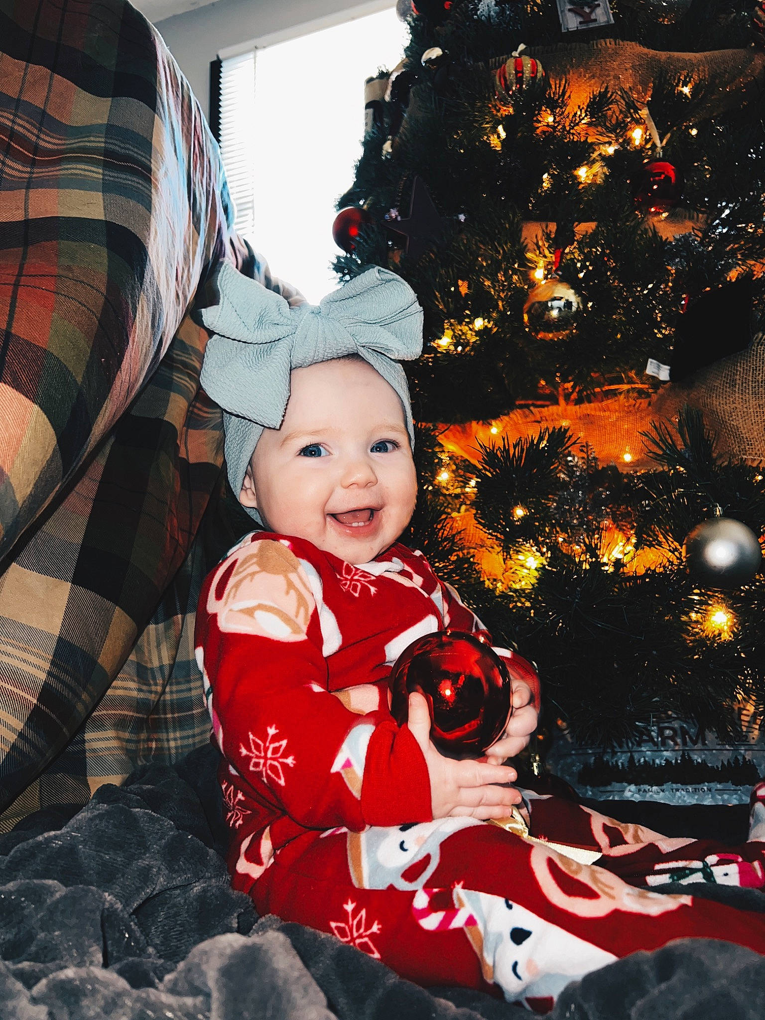 Blayke is registered to the contest to win money with this photo: baby, baby_toddler_clothing, christmas, christmas_decoration, christmas_ornament, christmas_tree, event, fun, happy, headwear, holiday, holiday_ornament, joy, ornament, person, plaid, sleeve, smile, tartan, toddler