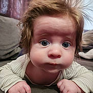 Vincent is registered to the contest to win money with this photo: baby, child, infant, face, expression, hair, blue_eyes, hands, couch, indoor, curious, cute, portrait, closeup, striped_clothing, skin, person, young, toddler, home