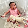 baby, infant, pink_dress, stuffed_animal, pacifier, white_bed, blanket, socks, cute, smiling, indoors, soft_toy, baby_girl, resting, cozy, child, portrait, comfort, sleepwear, happy