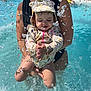 child, toddler, baby, swimming_pool, water, splash, hat, sunhat, swimsuit, person, adult, arms, summer, outdoor, fun, playing, splashing, happy, water_droplets, closeup