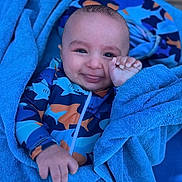Nassim participe au concours pour gagner de l'argent avec cette photo : baby, child, towel, blue, smile, face, hand, clothing, patterned_outfit, shark_pattern, infant, cute, wrapped, portrait, happy, skin, playful, young, person, indoors