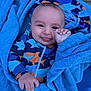 baby, child, towel, blue, smile, face, hand, clothing, patterned_outfit, shark_pattern, infant, cute, wrapped, portrait, happy, skin, playful, young, person, indoors