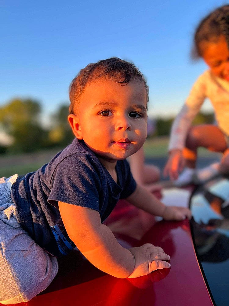 Mateo joined the competition — help win amazing prizes! arm, child, flash_photography, fun, gesture, grass, happy, leisure, orange, people_in_nature, person, play, recreation, sitting, sky, smile, standing, t_shirt, toddler, travel