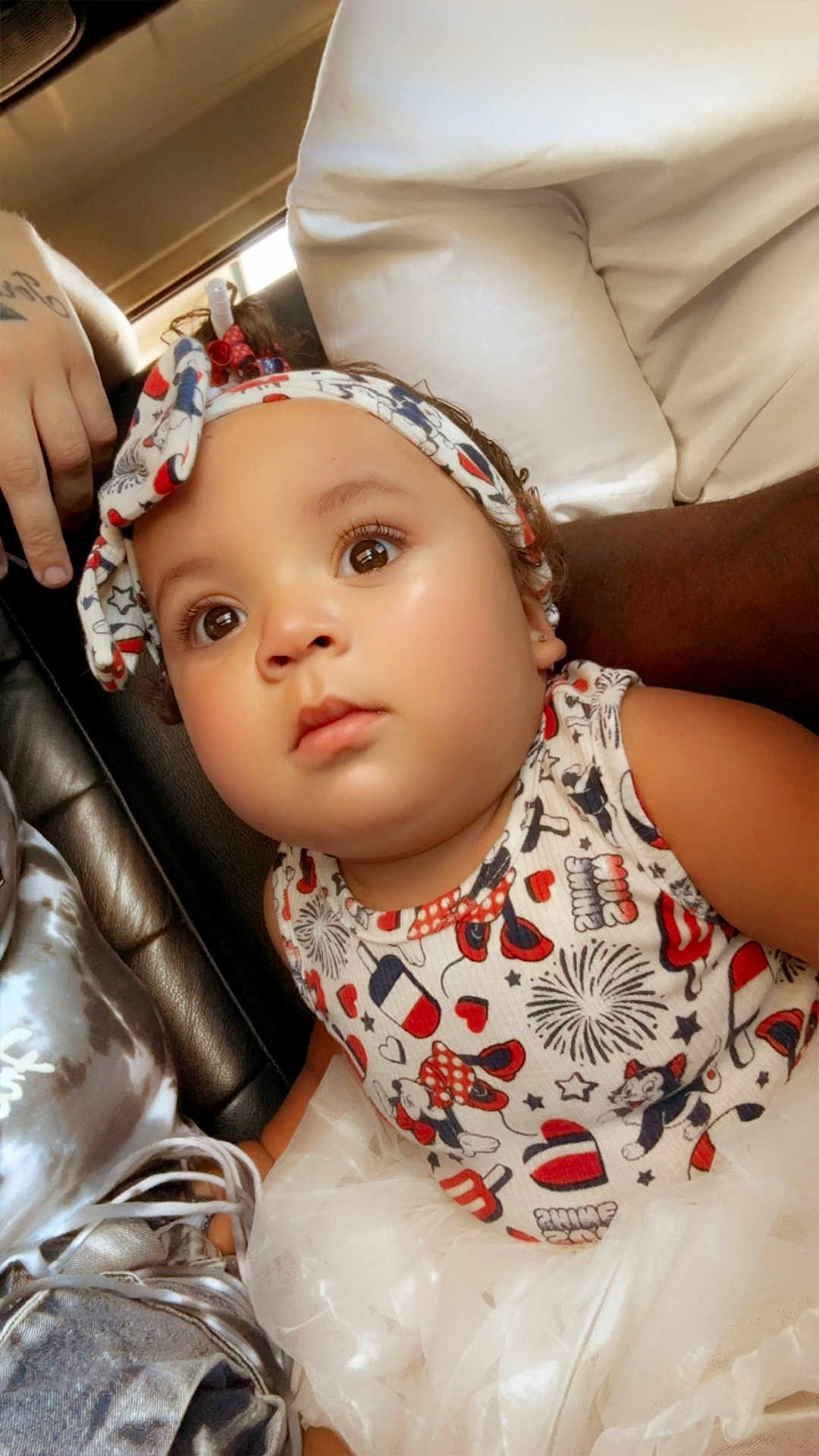 Neyehmoni is registered to the contest to win money with this photo: baby, child, headband, curious, closeup, face, big_eyes, colorful_clothing, patterned_outfit, soft_texture, tutu_skirt, indoor, person, cute, infant, expression, seated, skin, hand, light