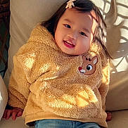 Shakira joined the competition — help win amazing prizes! child, toddler, smiling, portrait, seated, indoors, chair, sweater, fleece, yellow, deer, hair_bow, dark_hair, sunlight, window_shadows, casual_clothing, blue_jeans, happy, cute, photography