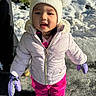 Shakira is registered to the contest to win money with this photo: toddler, child, snow, winter, outdoor, portrait, snow_clothing, winter_hat, pom_pom_hat, puffy_jacket, pink_pants, purple_mittens, boots, standing, snowy_ground, sunlight, playground, cold_weather, face, smiling