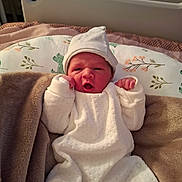 élio a rejoint le concours — aidez-le/la à gagner de superbes lots ! newborn, baby, infant, white_outfit, hat, blanket, pillow, bed, indoor, cozy, cute, small_hands, face, expression, sleepwear, soft, resting, child, person, lying_down