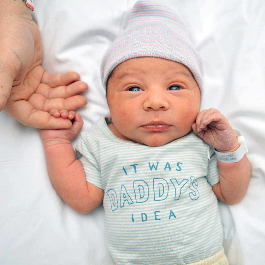 Ajanni is registered to the contest to win money with this photo: baby, beanie, bodypart, bonnet, cap, clothing, face, finger, glove, hand, hat, head, newborn, person, photography, portrait, t_shirt