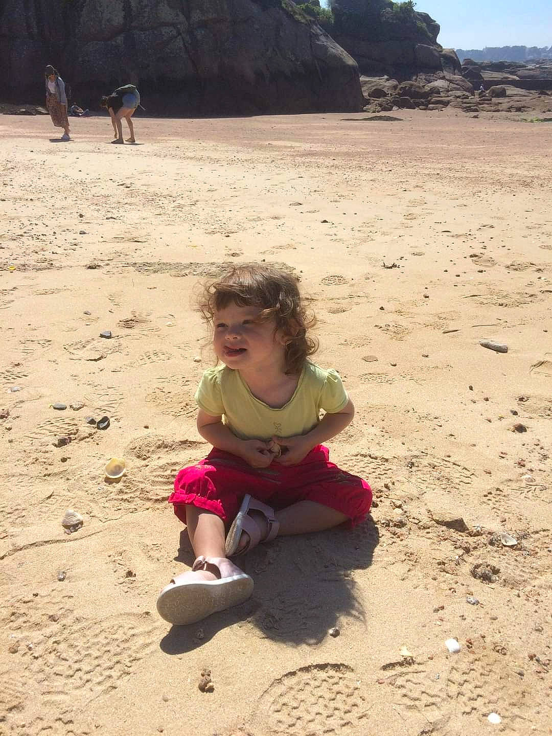 Olivia participe au concours pour gagner de l'argent avec cette photo : aeolian_landform, beach, body_of_water, child, fun, happy, landscape, leisure, people_in_nature, person, sand, shadow, shore, sitting, sky, soil, summer, sunglasses, toddler, travel