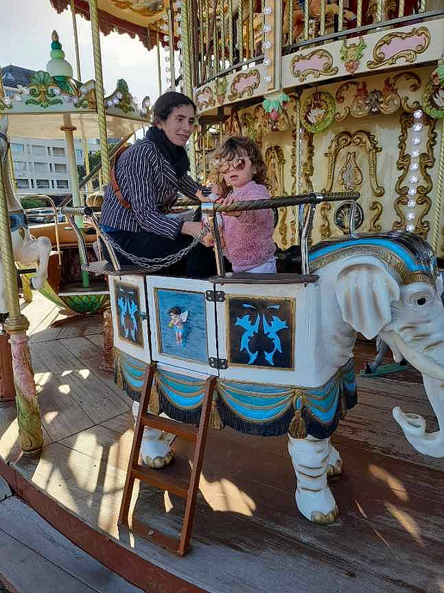 Olivia participe au concours pour gagner de l'argent avec cette photo : amusement_park, amusement_ride, carousel, chair, child, city, event, fair, fun, horse, horse_tack, leisure, nonbuilding_structure, person, recreation, room, temple, tourism, vacation, wood