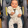 baby, child, car_seat, infant, braided_hair, cute, smiling, clothing, bee_pattern, socks, indoor, seat, person, cute_outfit, comfort, happy, young_child, portrait, casual, cozy