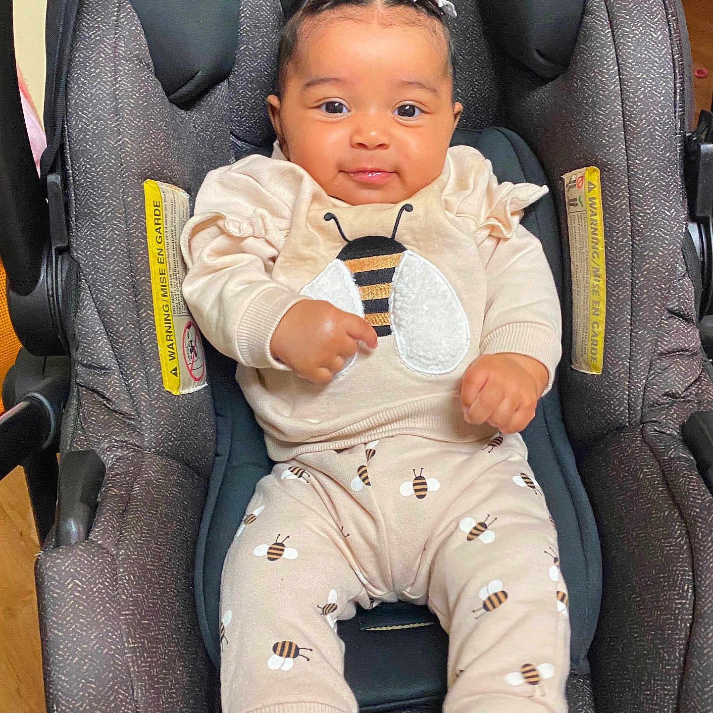 Carla Salazar is registered to the contest to win money with this photo: baby, child, car_seat, infant, braided_hair, cute, smiling, clothing, bee_pattern, socks, indoor, seat, person, cute_outfit, comfort, happy, young_child, portrait, casual, cozy