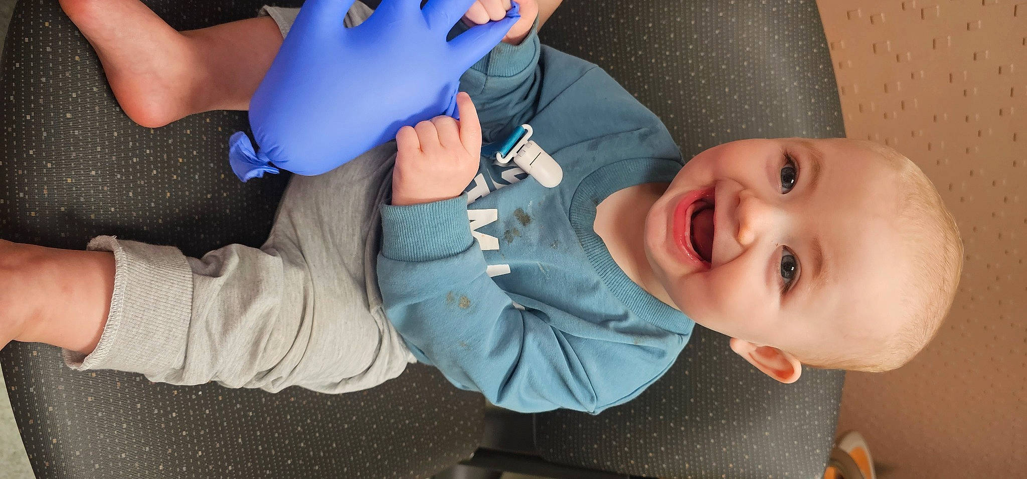 Edward is registered to the contest to win money with this photo: arm, baby, baby_toddler_clothing, blue, finger, fun, gesture, hand, happy, human_body, joy, knee, mouth, organ, person, plastic_bottle, skin, smile, thigh, thumb