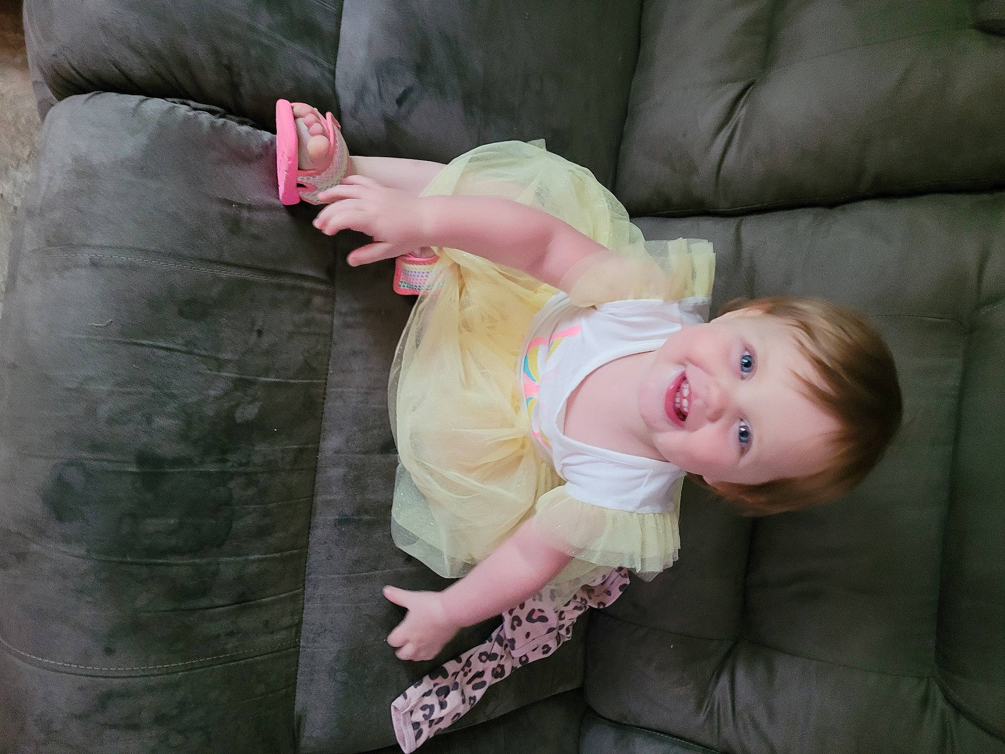 Myla is registered to the contest to win money with this photo: baby, baby_toddler_clothing, cheek, child, comfort, face, facial_expression, fun, gesture, grass, happy, human_leg, joy, leg, person, pink, sitting, skin, smile, textile