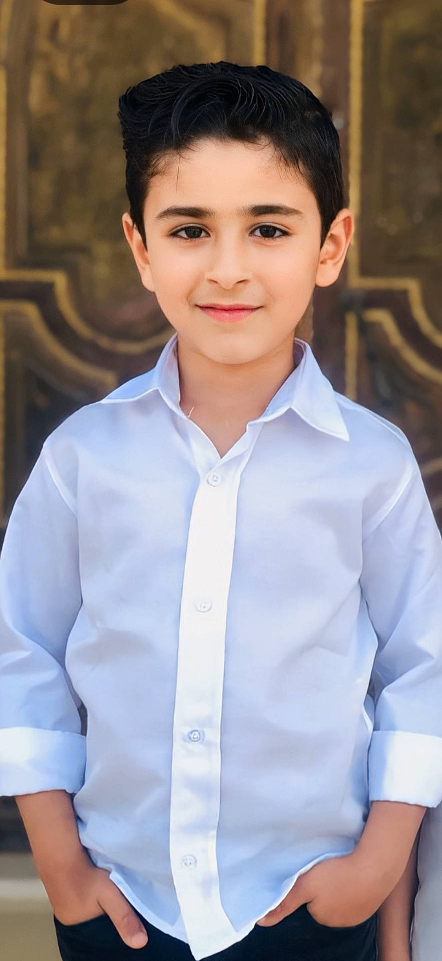 Mohammd joined the competition — help win amazing prizes! background_blur, black_hair, boy, casual, child, confident, cute, face, fashion, hands_in_pockets, happy, indoors, neat, person, portrait, posing, smile, standing, white_shirt, young