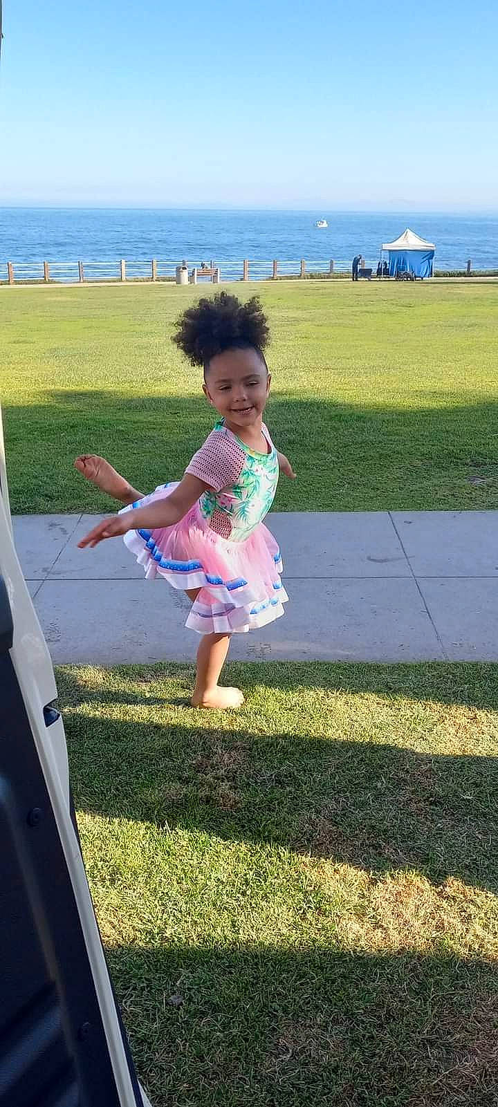 Maryann is registered to the contest to win money with this photo: baby_toddler_clothing, barefoot, fun, gesture, grass, grass_family, grassland, hairstyle, happy, human_body, joy, leisure, people_in_nature, person, plant, public_space, recreation, sky, standing, summer