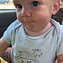 Koah is registered to the contest to win money with this photo: baby, car_seat, child, closeup, clothing, cute, expression, eyes, face, goat_illustration, hand, head, indoor, infant, onesie, person, portrait, sitting, skin, young_child