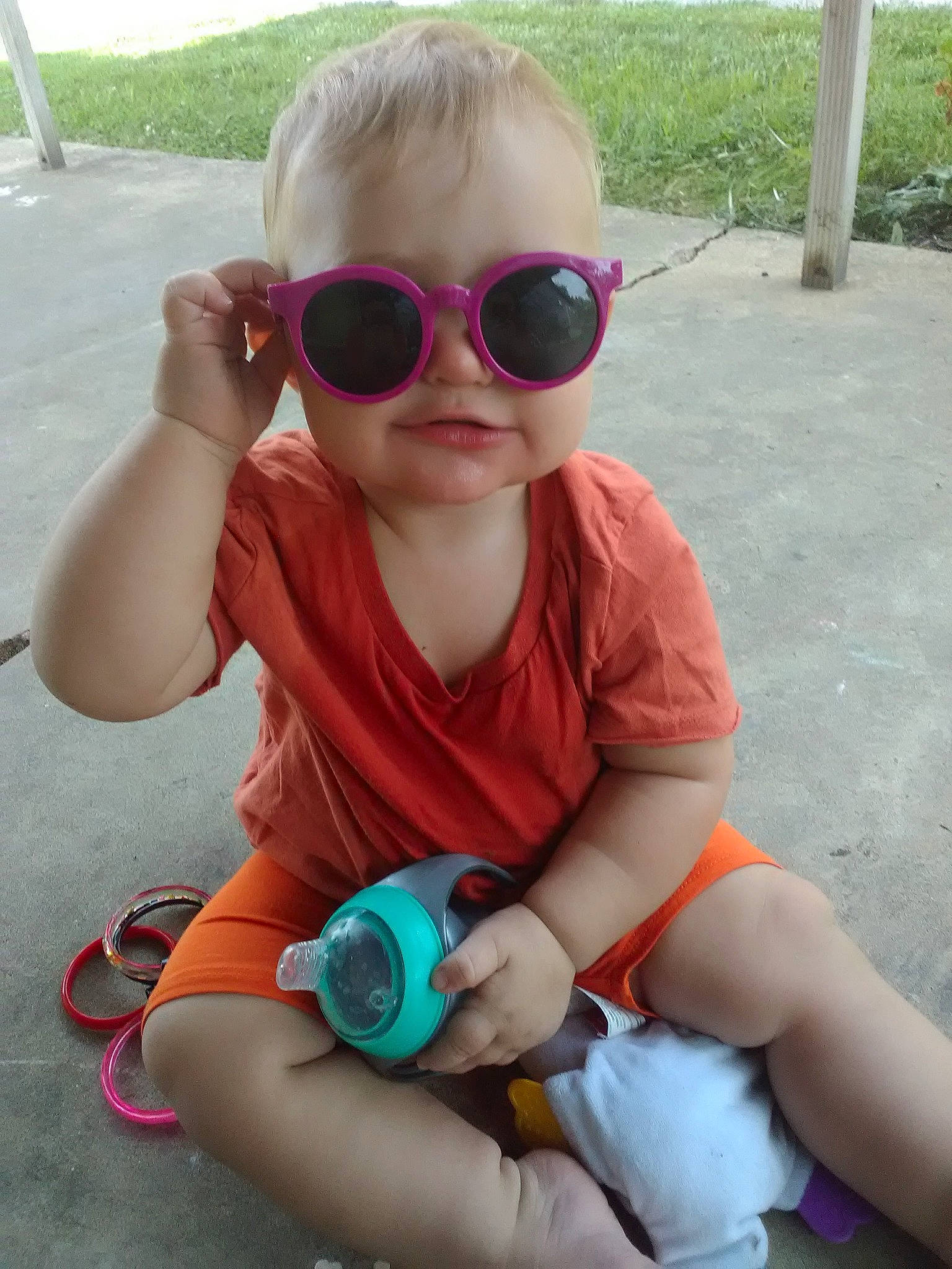 Lily is registered to the contest to win money with this photo: baby_toddler_clothing, cool, eyewear, face, finger, glasses, goggles, green, happy, head, lip, person, pink, plant, skin, sleeve, summer, sunglasses, toddler, vision_care