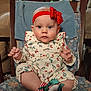 baby, child, infant, headband, bow, red, blue_eyes, outfit, cherry_pattern, socks, ribbon, chair, cushion, floral, indoor, portrait, cute, seated, hands, curious