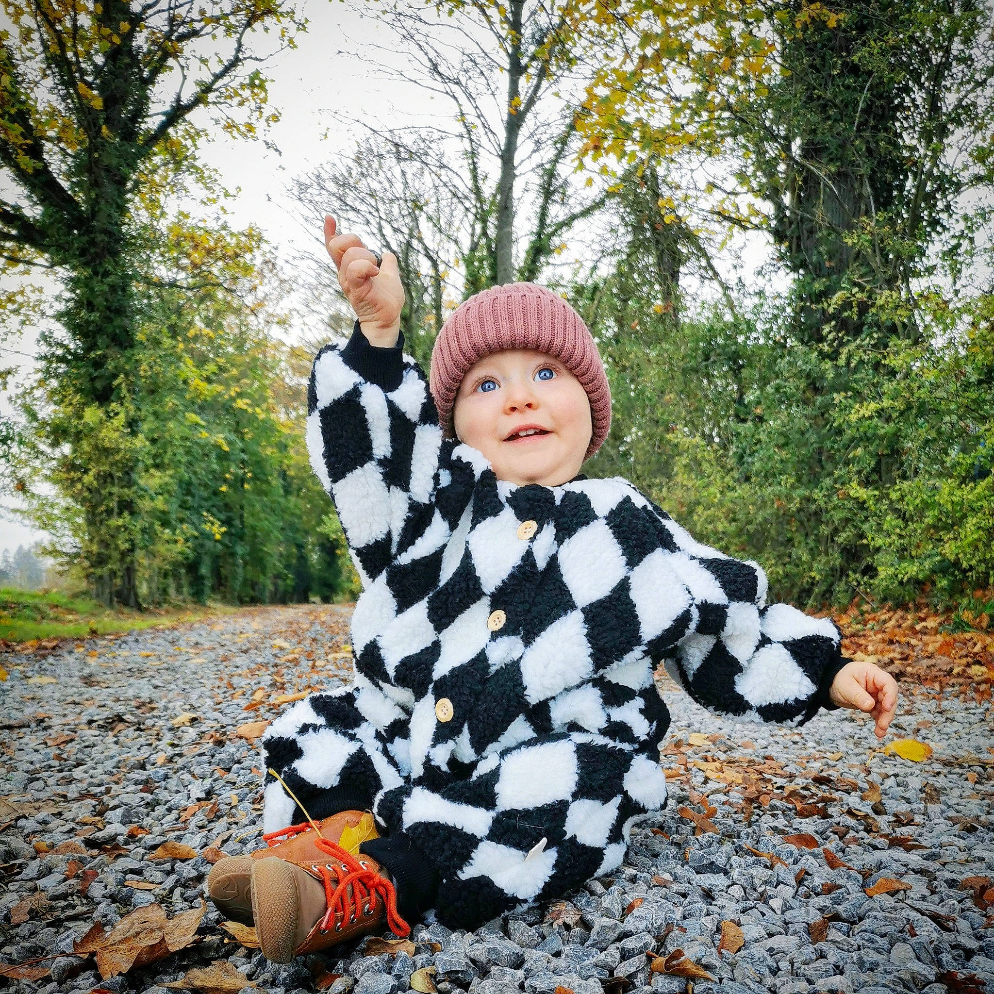 Théophile a rejoint le concours — aidez-le/la à gagner de superbes lots ! baby_toddler_clothing, ball, child, fun, fur, gesture, grass, happy, headgear, headwear, outerwear, pattern, people_in_nature, person, plant, recreation, sitting, sky, sleeve, toddler