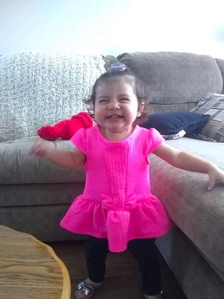 Isabel is registered to the contest to win money with this photo: baby_toddler_clothing, child, comfort, couch, eye, fun, gesture, hand, happy, joy, leg, leisure, magenta, person, pink, purple, skin, sky, sleeve, smile