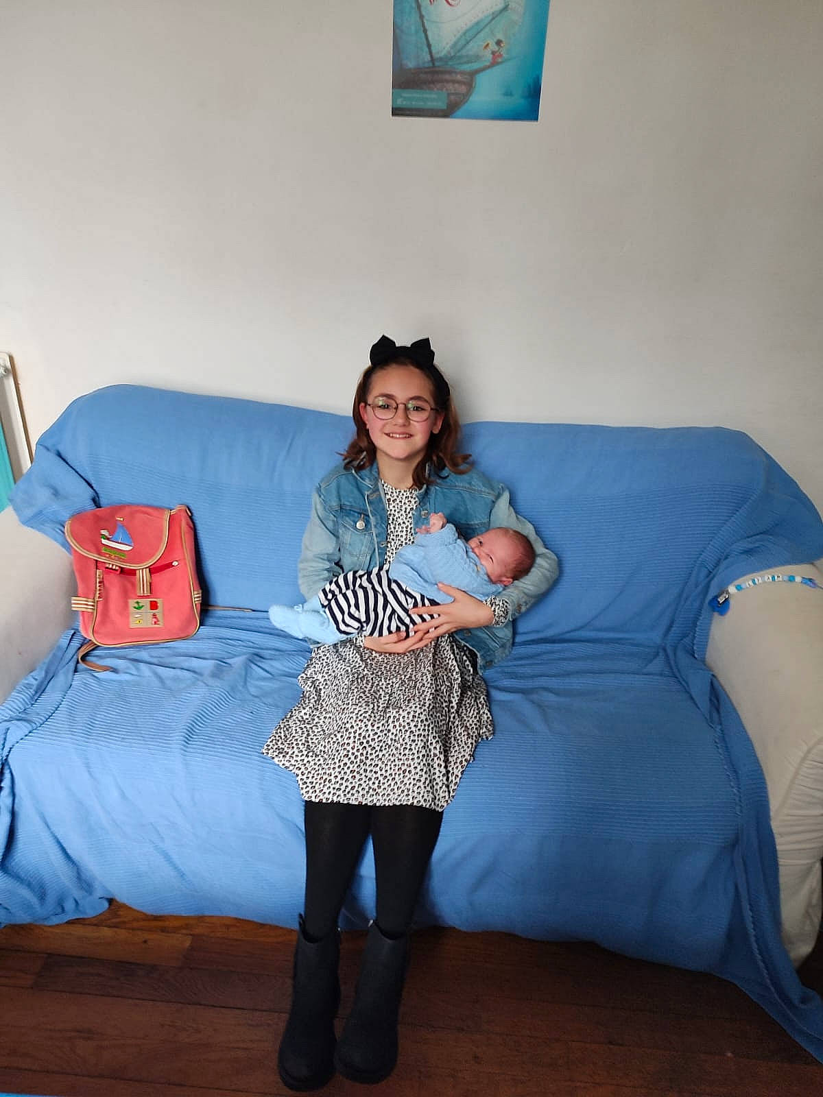 Lola participe au concours pour gagner de l'argent avec cette photo : blue, comfort, couch, electric_blue, event, floor, flooring, fun, furniture, happy, human_leg, interior_design, joy, knee, living_room, person, pillow, sitting, sleeve, smile