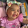baby, child, smiling, headband, pink_shirt, car_seat, infant, cute, happy, portrait, closeup, apparel, clothing, person, face, young_child, baby_girl, seat, text, accessory