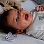 Laura participe au concours pour gagner de l'argent avec cette photo : baby, infant, smiling, lying_down, onesie, pacifier, bed, soft_furniture, happy, cute, animal_print, child, face, skin, hand, sleepwear, indoors, closeup, young, portrait