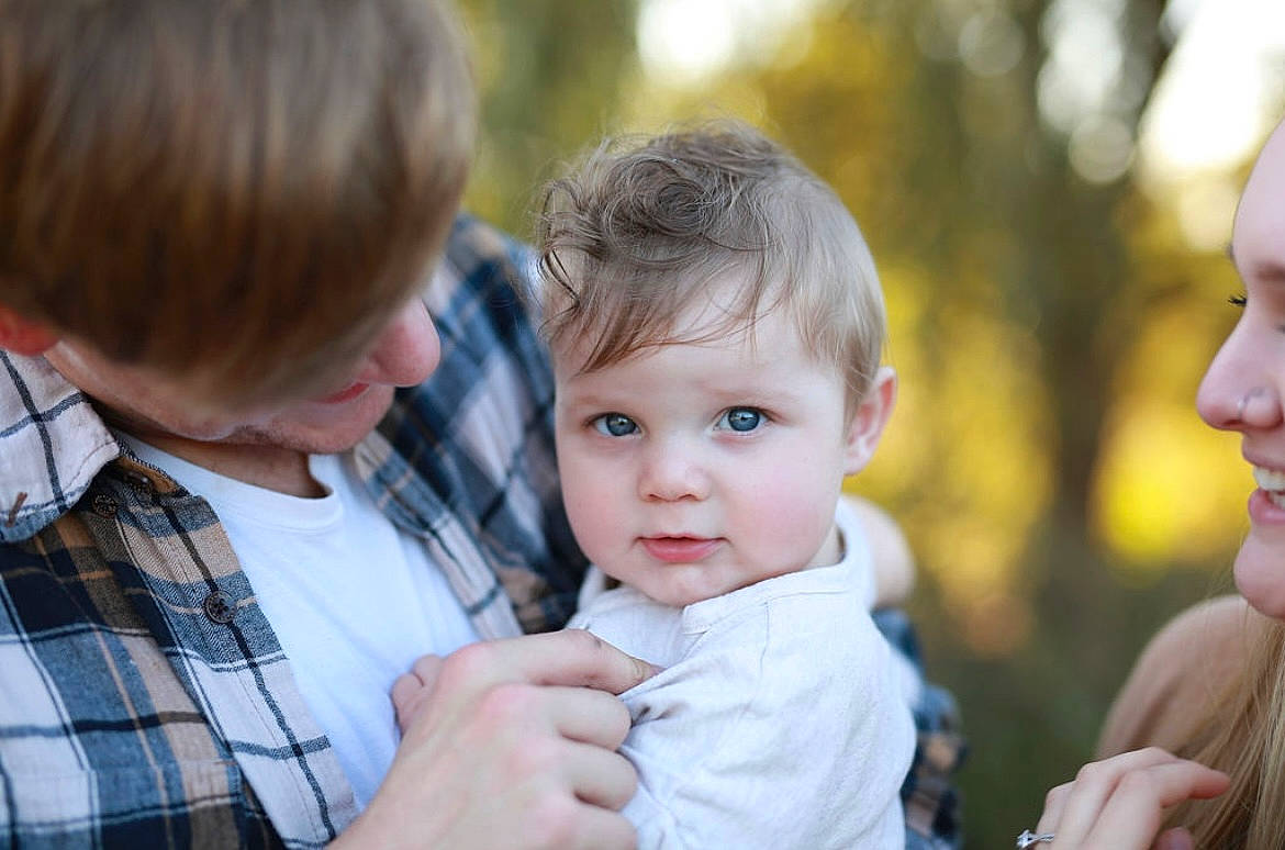 Jaxon is registered to the contest to win money with this photo: baby, child, dress_shirt, event, family, fun, gesture, grass, happy, iris, pattern, people_in_nature, person, plaid, portrait_photography, recreation, sharing, sitting, tartan, toddler
