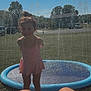 child, girl, swimsuit, water_splash, splash_pool, smile, outdoor, sunny, grass, backyard, trees, house, car, summer, play, fun, water, recreation, happy, daytime