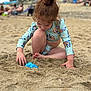 Macie is registered to the contest to win money with this photo: child, beach, sand, swimsuit, toy, playing, hair_bun, summer, outdoor, cute, fun, sunny, relaxation, vacation, sand_toy, casual, young, barefoot, daytime, sea_side